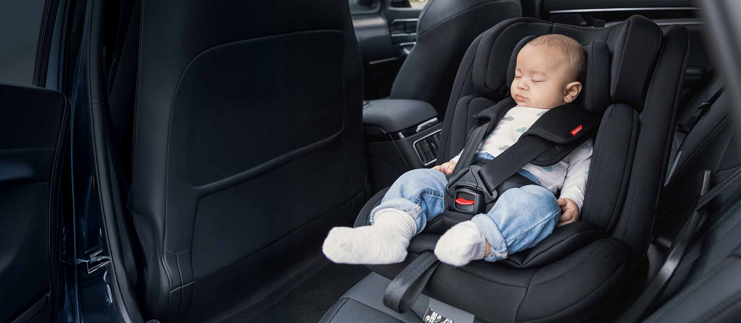 Un bebé duerme plácidamente mientras viaja su silla de coche giratoria Garaia i-Fix de Vivitta.